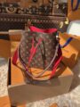 LV Neonoe Bucket Bag with brown monogram exterior, vibrant red interior, red drawstring closure and shoulder straps